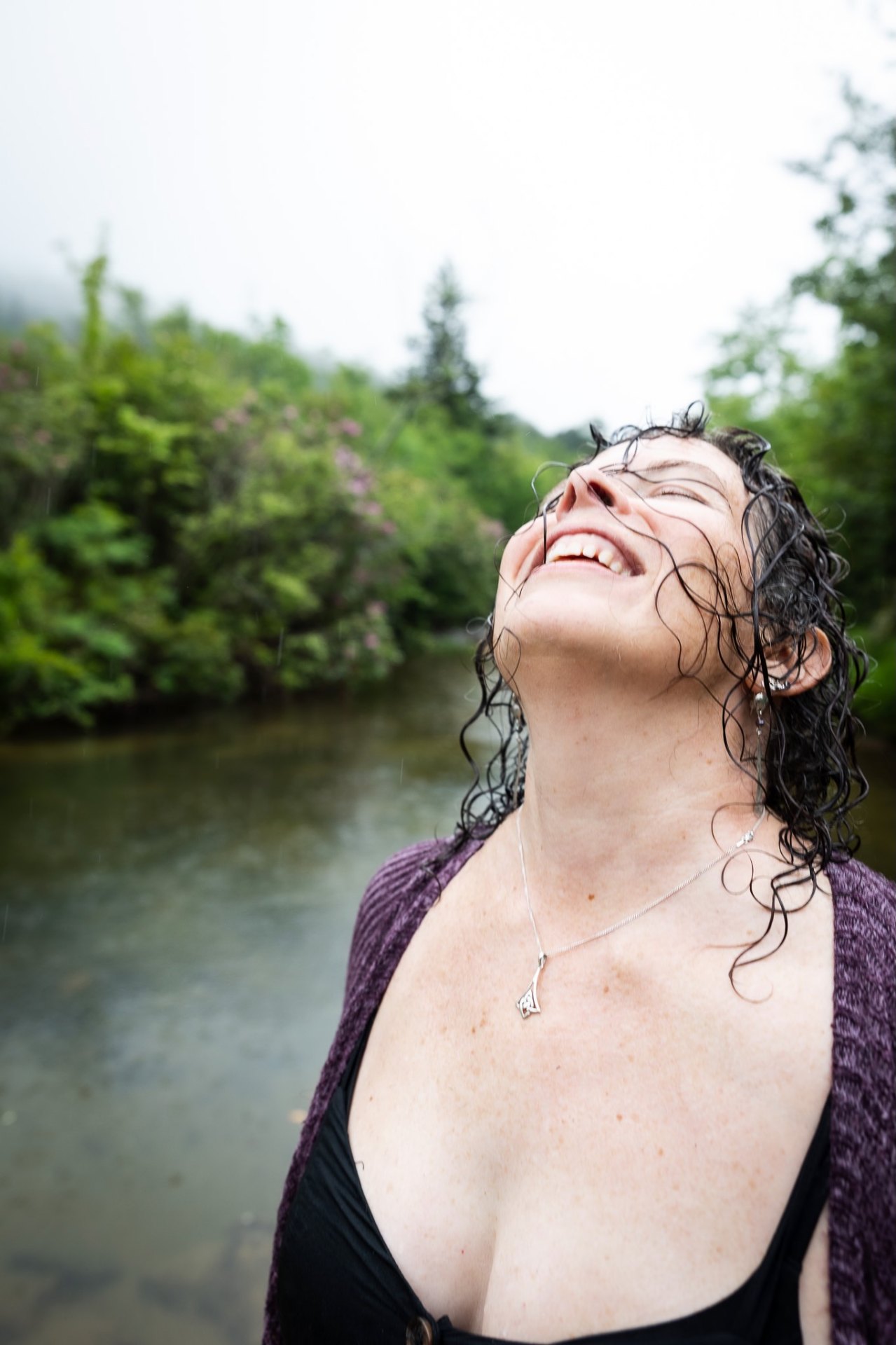 Bre laughing in the rain by the river.